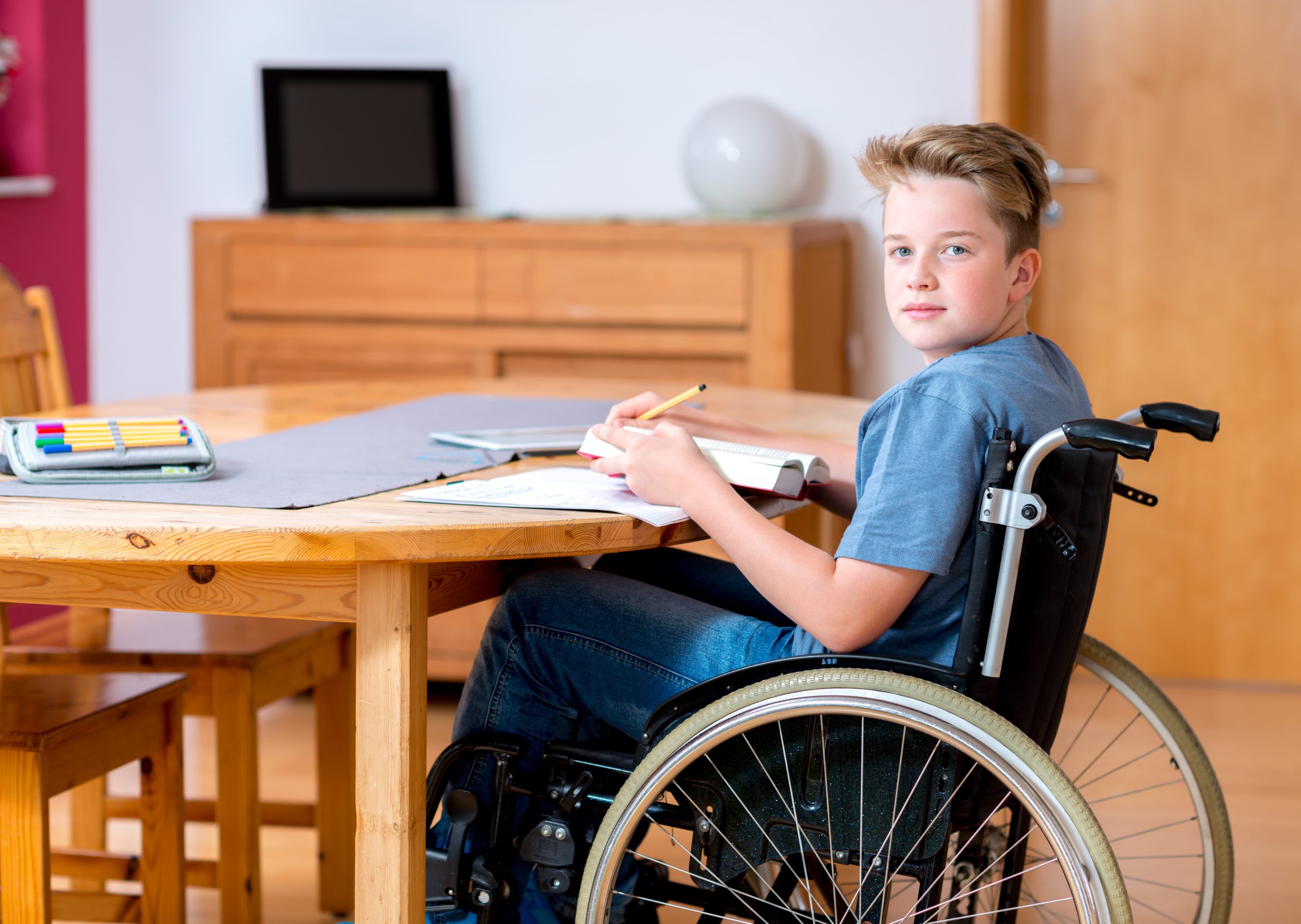 disabled boy in wheelchair doing homework